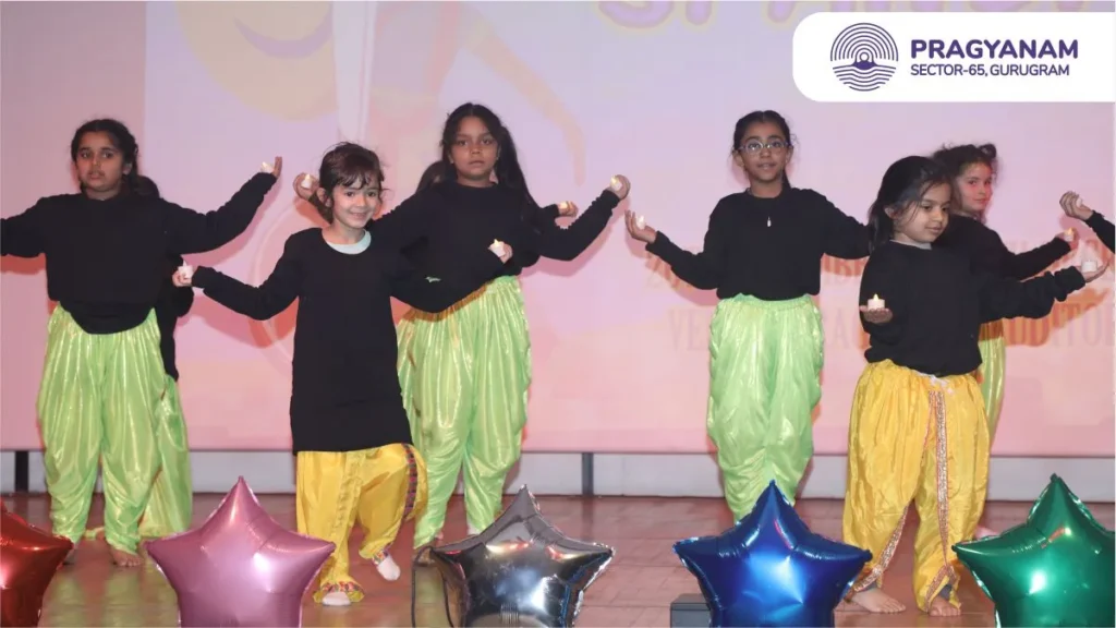 A group of children performing a dance on stage A group of children performing a dance on stage