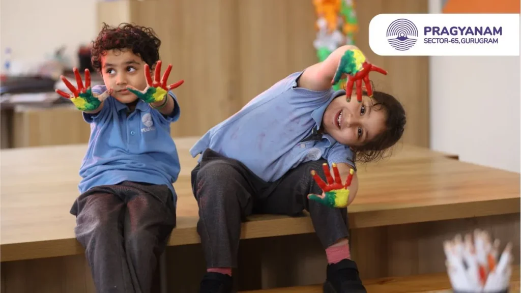 Two children with painted hands sitting on a table Two children with painted hands sitting on a table